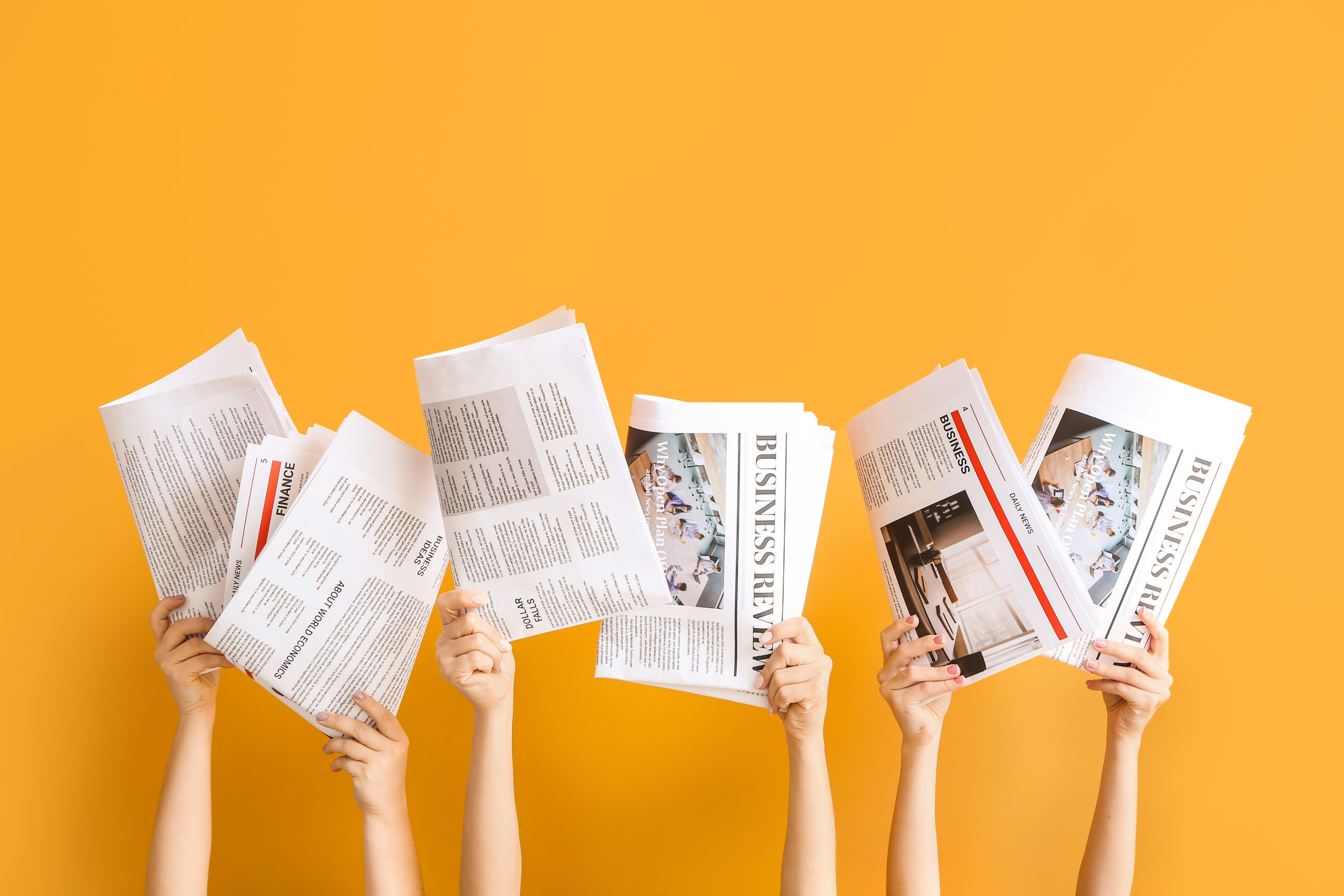 Female hands with newspapers on color background
